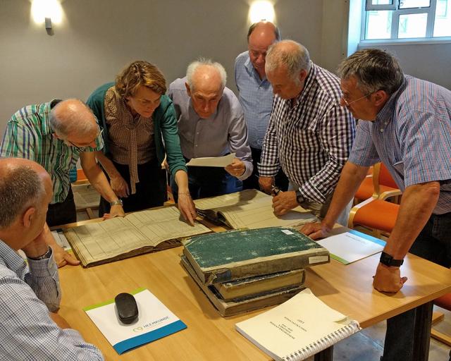 Hulgroepen en cursussen: erfgoedvrijwilligers buigen zich over enkele historische documenten.