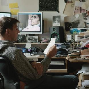 Dries Meddens in zijn studio, waar hij zijn familiegeschiedenis omzette in een documentaire. Hard aan het werk en omringd door computerschermen.